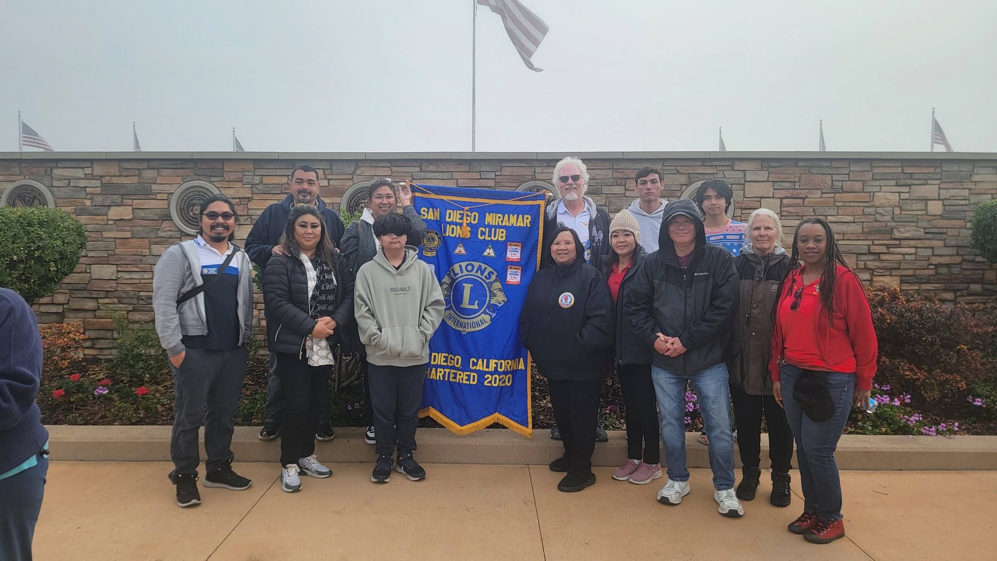 San Diego Miramar Lions Club members holding the club banner at Miramar National Cemetery